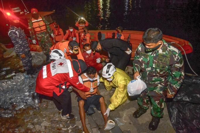 Rescue team members evacuate one of six survivors of a capsized passenger boat carrying 16 people in the Sunda strait near Anak Krakatau in Merak, Indonesia's Banten province on June 20, 2020. Photo: AFP