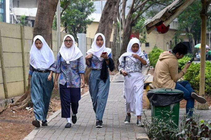 A group of young women make their way along a street in Jakarta on Sept 19, 2019. Indonesia is set to vote on a plan to outlaw gay and pre-marital sex while beefing up its blasphemy laws in a shakeup fuelled by religious conservatism and slammed by rights groups Thursday. Photo: AFP