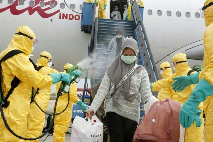 Health officials disinfect the evacuees from Wuhan, who will be quarantined on the island of Natuna for two weeks (AFP Photo)