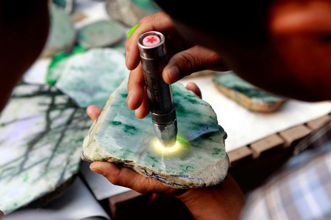 A close-up view of a man inspecting the quality of a Jade stone at the Jade market in Mandalay, Myanmar, 06 April 2015. Photo: Pyae Sone Aung/EPA
