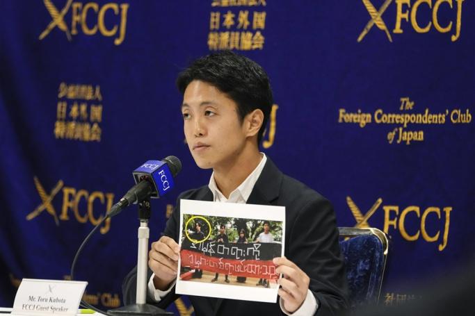 Japanese documentary filmmaker and journalist Toru Kubota poses with a photo showing him holding a banner which he said he was forced to hold after his detention and which was used by the Myanmar army as evidence against him, during a news conference at the Foreign Correspondents' Club of Japan (FCCJ) in Tokyo, Japan, 28 November 2022. Photo: EPA