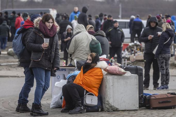 Ukrainian citizens are seen arriving at the Medyka pedestrian border crossing fleeing the conflict in their country, in eastern Poland on 27 February 2022. Photo: AFP