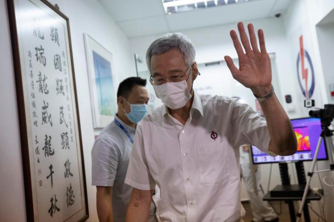 Singapore's Prime Minister and secretary general of the ruling People's Action Party (PAP) Lee Hsien Loong waves as he leaves a PAP branch office after the sample preliminary results of the general elections were announced in Singapore, 11 July 2020. Photo: EPA
