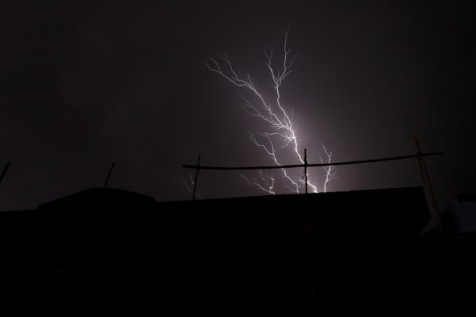 (File) Lightning bolts strike out of dark clouds above a construction site in Yangon, Myanmar. Photo: EPA