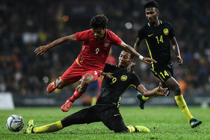 Malaysia's Nor Azam Azlin (C) fights for the ball with Myanmar's Aung Thu (L) during their men's football match at the 29th Southeast Asian Games (SEA Games) at Shah Alam Stadium in Shah Alam, outside Kuala Lumpur on August 21, 2017. Photo: Mohd Rasfan/AFP
