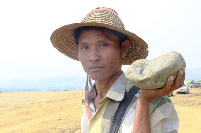Caption - Maung Aye, a miner who has worked in Hpakant for many years, carries a piece of low-grade jade. Photo: Htet Khaung Linn / Myanmar Now
