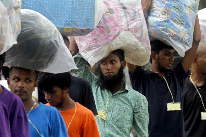 Migrants, who are to be repatriated from Myanmar to Bangladesh, carry their belonging as they queue at the Taung Pyo temporary refugee camp near the Bangladesh border in MaungDaw township, Rakhine State, western Myanmar, 08 June 2015. Photo: Nyunt Win/EPA

