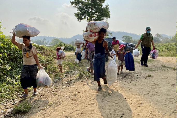This handout photo taken and released on April 11, 2023 by the Royal Thai Army shows displaced people from Myanmar carrying belongings as they make their way to the Moei river on the Thai-Myanmar border to return from Thailand's Mae Sot district in Tak province. Photo: AFP