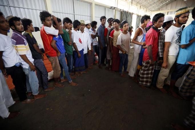 Migrants line up for their meal at a temporary shelter in Kuala Langsa, Aceh, Indonesia, 17 May 2015. Photo: Hotli Simanjuntak/EPA

