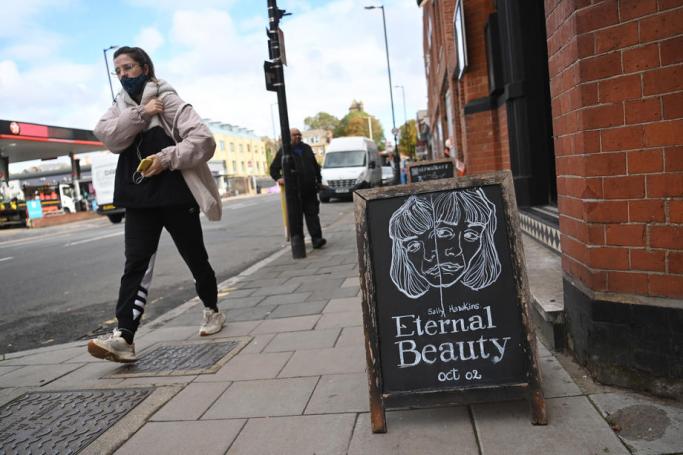 A woman wearing a face mask passes the independent Arthouse cinema in Crouch End in north London, Britain, 15 October 2020. Photo: EPA