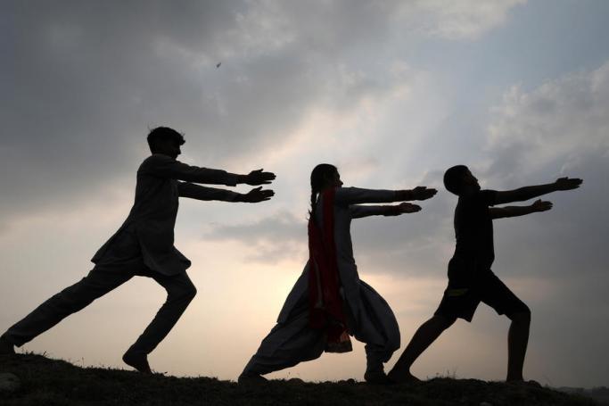 Indian people practice yoga on the eve of World Yoga Day at the village of Jalot, India, 20 June 2020. Photo: EPA