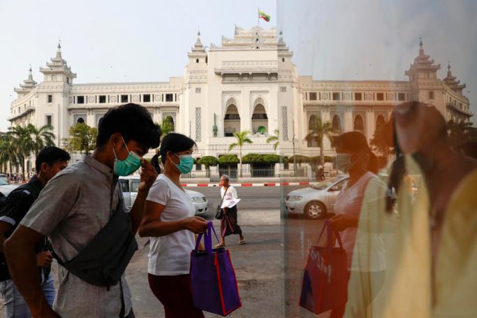 Myanmar people wearing protective face masks walk in front of the City Hall in Yangon, Myanmar, 01 March 2020. Photo: Lynn Bo Bo/EPA