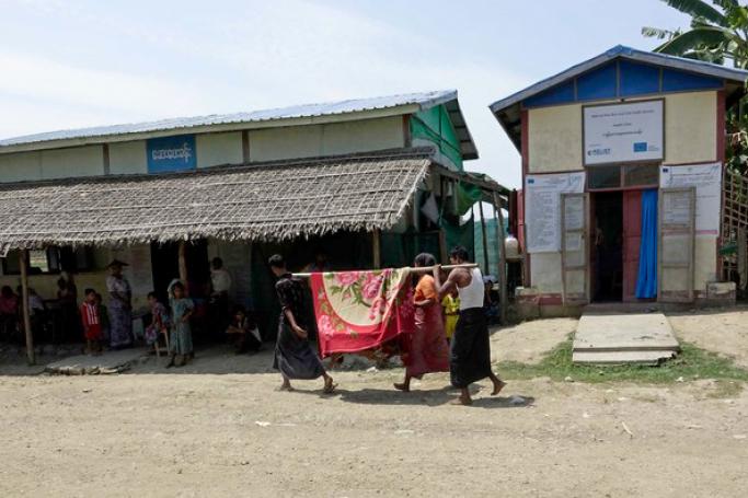 Muslim people carry a sick person (obscured) to a clinic near the internally displaced person (IDP) camp in MayBon Township, Rakhine State. Photo: EPA
