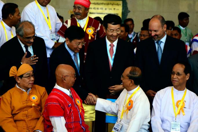 Myanmar president Thein Sein (2 R) greets Chinese Ambassador to Myanmar Hong Liang (back, 2-R) as leaders of ethnic armed groups (L), Myanmar vice president Sai Mauk Kham (R) and international witnesses, are seen during a Nationwide Ceasefire Agreement (NCA) ceremony at the Myanmar International Convention Center (MICC) in Naypyitaw, Myanmar, 15 October 2015.Photo: Aung Htet/EPA
