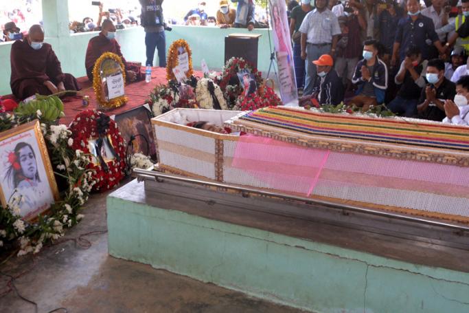 Buddhist monks pray by the body of Mya Thwate Thwate Khaing in an open coffin during her funeral service, following the young protester's death after being shot at a rally against the military coup, in Naypyidaw on February 21, 2021. Photo: AFP