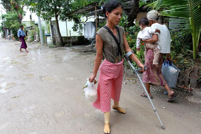 Myanmar refugee Myat Win, 27, who lost both her legs after stepping on a landmine inside Myanmar, near the Thai border area, walks into the Mae Tao clinic grounds in the Thai - Myanmar border city of Mae Sot, Thailand. Photo: EPA
