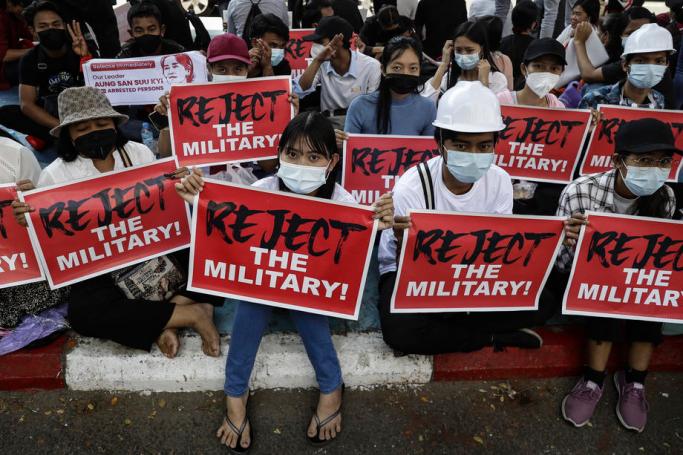 Protesters hold placards during a protest against the military coup in Yangon, Myanmar, 13 February 2021. Photo: Lynn Bo Bo/EPA