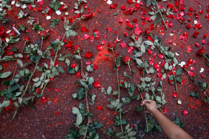 A woman lays a red rose during a ceremony marking the 32nd anniversary of the 8888 Uprising in Yangon, Myanmar, 08 August 2020. Photo: Lynn Bo Bo/EPA