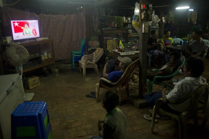 (File) People watch National League for Democracy chairperson Aung San Suu Kyi delivers a speech on air on Myanmar Radio and Television (MRTV). Photo: AFP