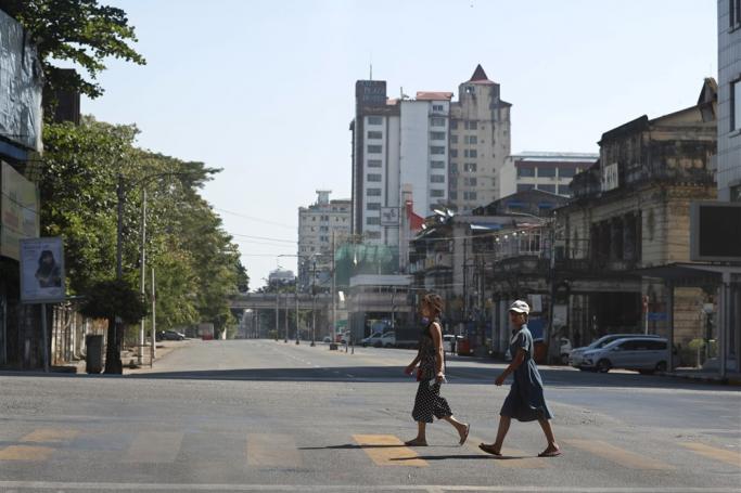(File) Girls cross the empty street in downtown Yangon, Myanmar, 10 December 2021. Photo: EPA