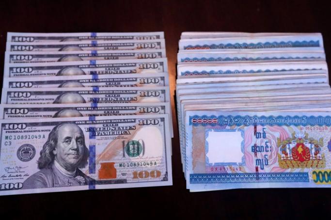 Myanmar Kyats and US dollar bills displayed on a table in Yangon, Myanmar, 14 August 2023. Photo: EPA