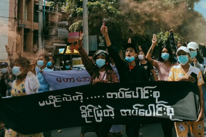 This photo taken and received courtesy of an anonymous source via Facebook on June 24, 2021 shows protesters holding flares as they take part in a demonstration against the military coup in Mandalay.  Photo: AFP