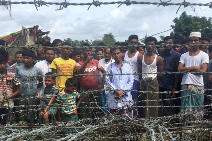 Rohingya refugees gather near the fence in the "no man's land" zone between Myanmar and Bangladesh border as seen from Maungdaw, Rakhine state during a government-organized visit for journalists on August 24, 2018. Photo: Hla Hla Htay/AFP