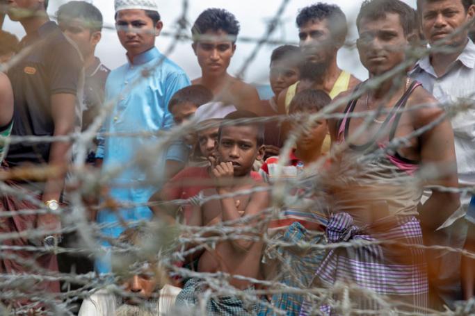 Rohingya refugees gather near the fence in the "no man's land" zone between Myanmar and Bangladesh border as seen from Maungdaw, Rakhine state during a government-organized visit for journalists on August 24, 2018. Photo: Phyo Hein Kyaw/AFP