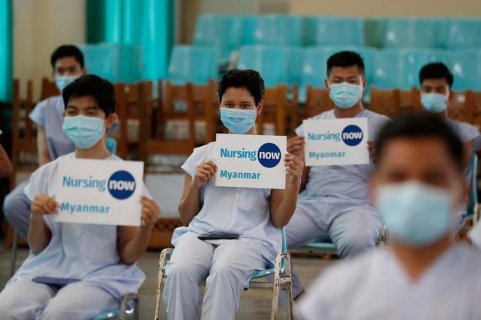 Nurses hold placard and pose for photo before the press conference of Yangon region Covid committee at the Central Institute of Civil Service (Lower Myanmar) in Yangon, Myanmar, 21 April 2020. Photo: Nyein Chan Naing/EPA