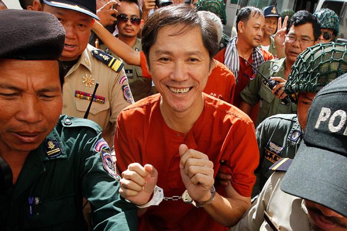 Ny Sokha (C), Head of Monitoring of Cambodian Human Rights and Development Association (ADHOC), is escorted by police officers while arriving at the Appeals Court in Phnom Penh, Cambodia, 13 June 2016. Photo: Kith Serey/EPA
