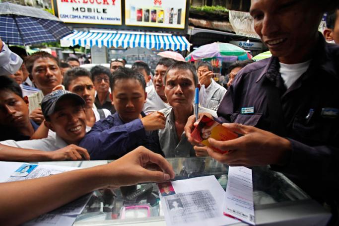 A Myanmar man buys an Ooredoo mobile sim card in Yangon. Photo: Lynn Bo Bo/EPA