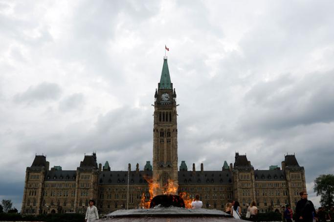 The parliament buildings are seen through the centennial flame in the Canadian capital of Ottawa, Ontario, Canada. Photo: Stephen Morrison/EPA
