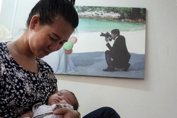 This photo taken on October 20, 2018 shows Panei Mon, wife of jailed journalist Wa Lone, cradling their two-month-old baby girl Thet Htar Angel in their Yangon apartment before leaving for a visit in Insein prison. Photo: Phoe Hein Kyaw/AFP
