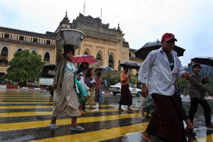 The Myanmar parliament has been urged to reject or extensively revise four controversial laws involving religion and women. People cross the road near Yangon City Hall, Yangon, Myanmar, March 16, 2011. EPA
