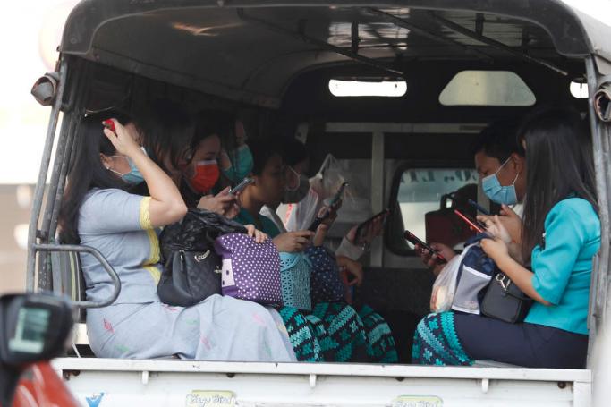 People wear masks as they sit in the back of a truck in Yangon, Myanmar. Photo: Nyein Chan Naing/EPA