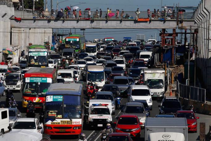 Traffic builds up on a road outside a bargain market in Quezon City, Metro Manila, Philippines. Photo: EPA