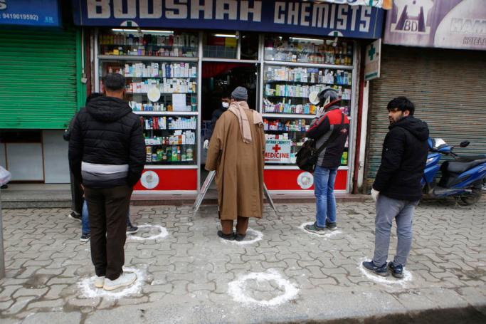 People stand on designated areas to maintain social distancing as they queue outside a medical store during a government-imposed nationwide lockdown as a preventive measure against the Covid-19 disease caused by the SARS-CoV-2 coronavirus, in Srinagar, the summer capital of Indian Kashmir, 26 March 2020. Photo: EPA