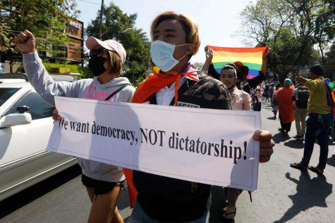 LGBT members hold placards and shout slogan as they march in front of the US Embassy during a protest against the military coup, in Yangon, Myanmar, 10 February 2021. Photo: EPA