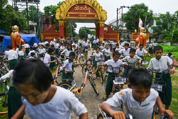 In this picture taken on June 18, 2019, students ride bicycles, previously used in bike-sharing companies and shipped from Singapore, which have been donated as part of the "Lesswalk" scheme in the compound of a Buddhist monastery on the outskirts of Yangon. Photo: Ye Aung Thu/AFP