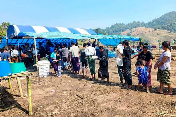 (File) People fleeing due to fighting between the military and the Karen National Union (KNU) line up to receive food at a temporary lodging for internally displaced people (IDPs) in Karen state, along the Thai-Myanmar border, on December 25, 2021. Photo: AFP