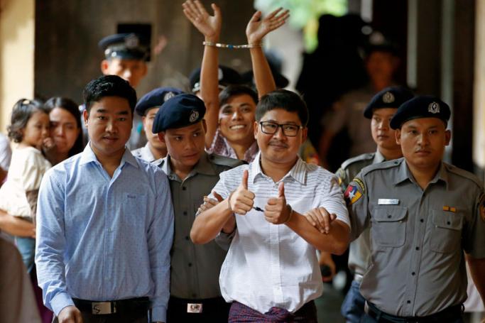 (FILE) - Reuters journalists Wa Lone (C-front) and Kyaw Soe Oo (C-back) gesture as they arrive at Insein township court, in Yangon, Myanmar, 27 August 2018. Photo: Lynn Bo Bo/EPA
