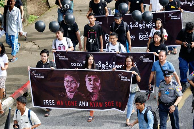 Journalists and activists hold banners with the portrait of Reuters journalists Wa Lone and Kyaw Soe Oo, as they shout slogans during a protest for Rights to Information in Yangon, Myanmar, 01 September 2018. Photo: Nyein Chan Naing/EPA