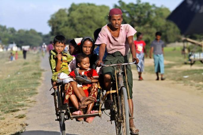 Rohingya family members ride a trishaw as they travel through Thet Kel Pyin Muslim refugee camp near Sittwe, Rakhine State, western Myanmar, November 11, 2014. Photo: Nyunt Win/EPA
