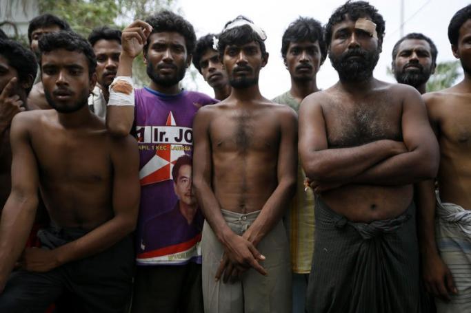 Refugee from Myanmar and Bangladesh line up after being save from the sea in Kuala Langsa, East Aceh, Indonesia, 15 May 2015. Photo: Hotli Simanjuntak/EPA
