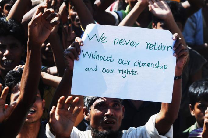 (File) A Rohingya refugee carries a placard that says "We never return" at a protest against a disputed repatriation programme at the Unchiprang refugee camp near Teknaf on November 15, 2018. Photo: Dibyangshu Sarkar/AFP