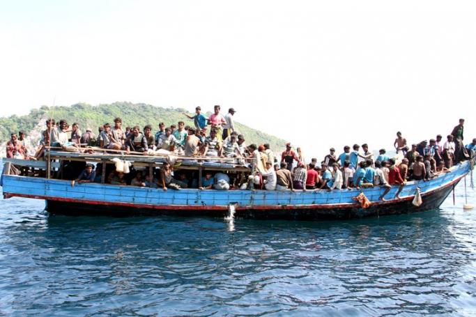 Rohingya refugees from Myanmar gather on a boat as they are being rescued by Thai Navy officers before they head to Malaysia, at the Andaman coast, Phuket island, southern Thailand, January 29, 2013. Photo: Yongyot Pruksarak/EPA
