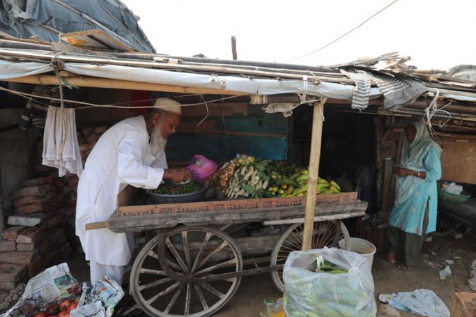 (File) A Rohingya Muslim man prepares a vegtable cart to sell, in a makeshift settlement in Madanpur Khadar, in New Delhi, India, 22 August 2017. Photo: Rajat Gupta/EPA