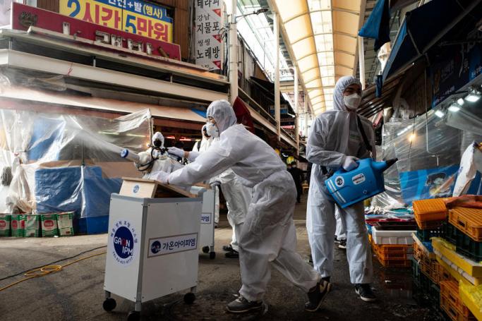 Workers spray disinfectant as a precaution against COVID-19 at Saemaeul traditional market in Seoul, South Korea, 26 February 2020. Photo: EPA
