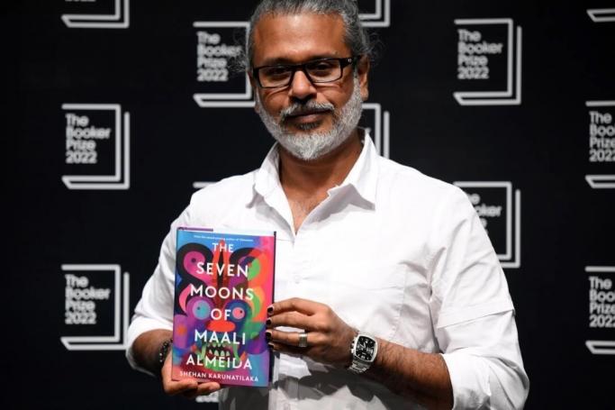 Sri Lankan author Shehan Karunatilaka holds his book 'The Seven Moons of Maali Almeida' during a photocall at the Shaw Theatre in King's Cross in London. Photo: AFP