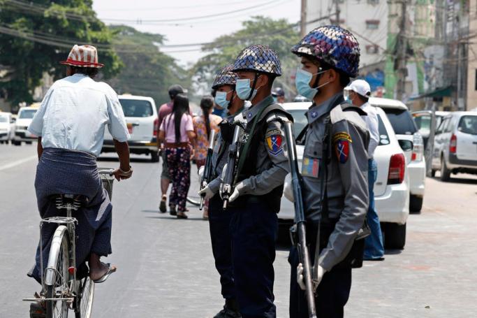 (File) Police, wearing face masks as a preventive measure against the spread of the COVID-19 novel coronavirus, stand guard during a prisoner release in front of Insein Prison in Yangon on April 17, 2020. Photo: AFP